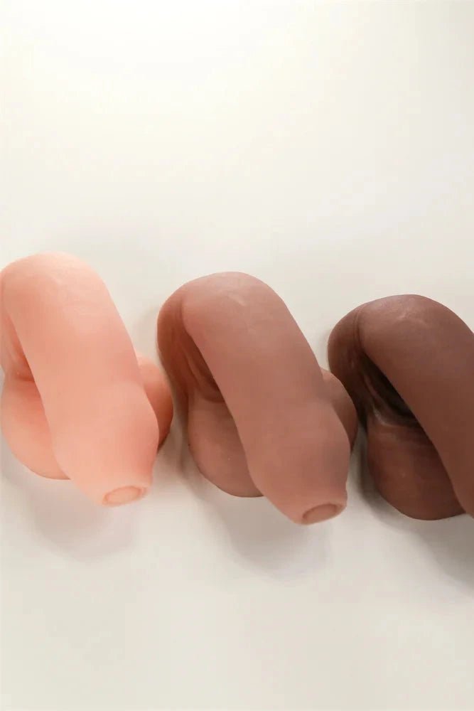 Three silicone earplugs in different colors on a white background