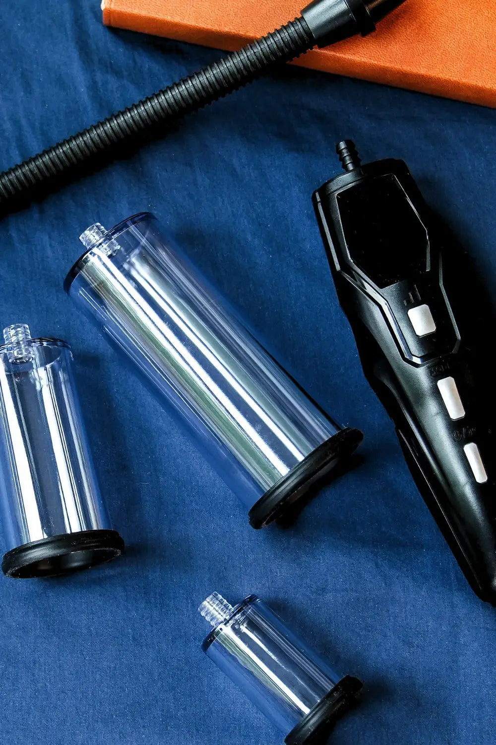 Black handheld device with clear cylindrical attachments on a blue surface