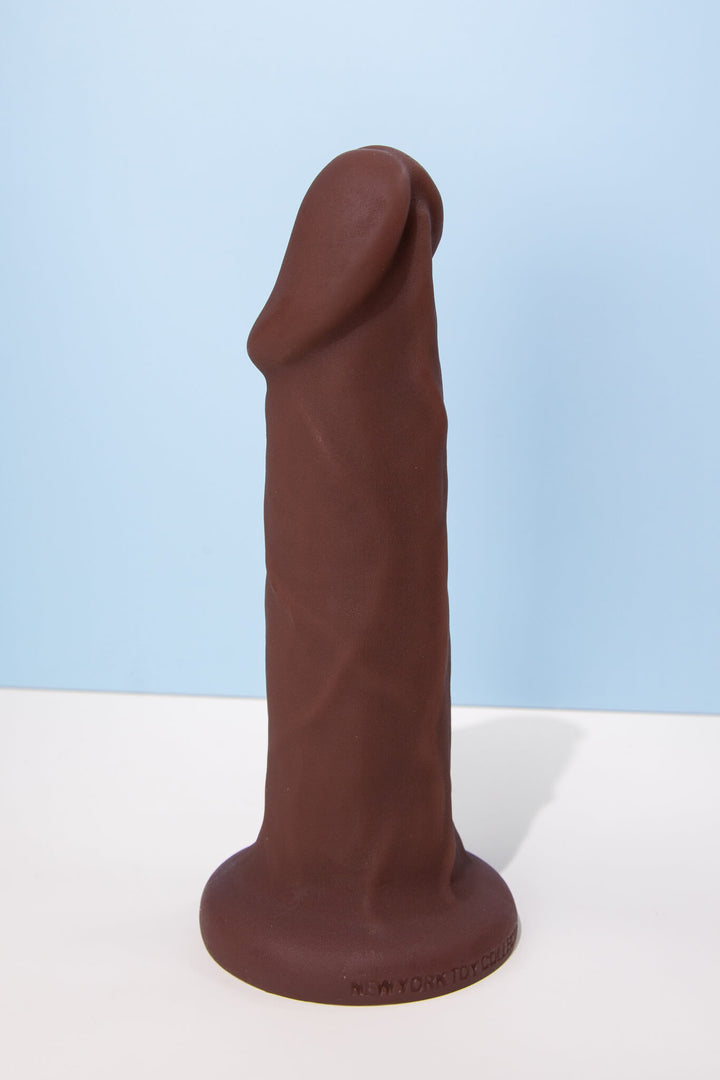 Chocolate-colored silicone product on a white surface with a light blue background